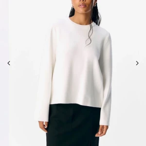 Vit långärmad tröja - Snygg vit långärmad tröja med enkel och clean design. Tröjan har rund hals och en loose passform som ger en chill vibe. Perfekt att matcha med jeans eller kjol för en stilren look.