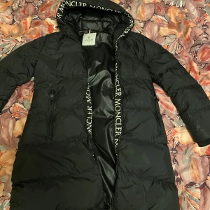 Svart Moncler dunjacka med huva - Jackan är i fint skick storlek S Köpt på Vinted men var tyvärr för liten för mig.  (Ej äkta) 