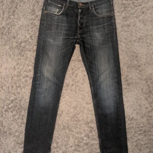 Svarta Lee Daren jeans W31 L30 - Snygga svarta Lee Daren jeans med slitningar och tvättad look. Klassisk femficksmodell med raka ben och normal passform. Jeansen har Lee-logga på bakfickan och är tillverkade i slitstarkt denimtyg. 