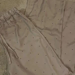 Beige pyamasbyxor med prickigt mönster - Snygga pyjamas byxor i sidenmaterial jättesköna för att chilla hemma 