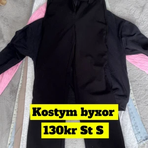 Svarta kostymbyxor i storlek S - Snygga svarta kostymbyxor i klassisk rak modell. Perfekta för dig som gillar stilrena och enkla plagg. Byxorna har en smal passform och är tillverkade i ett mjukt material som sitter bekvämt hela dagen.