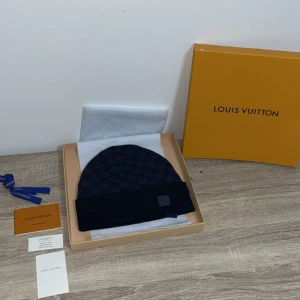 Mörkblå Louis Vuitton mössa - mörk blå lv mössa helt ny aldrig amvänd kommer med allt som är i bilden jag tar byten beror på vad det är och pris kan diskuteras. säljer för att fick den som present men passade inte mig. och jag har inte kvitto tyvär.