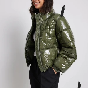 Grön glansig pufferjacka - Säljer en grön pufferjacka, jackan har dragkedja och tryckknappar framtill, och fickor på sidorna🥰🫰🏼Perfekt för dig som vill ha en cool och varm look under kyliga dagar❄️ Köptes för 699😌