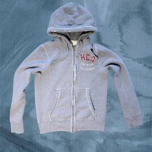 Grå hoodie från Hollister  - Tvärrrfet hoodie från hollister i stl M. Asfeta vintage slitningar som är fabriksgjorda. Dm.a för fler bilder och mått :). Lämna också gärna ett prisförslag så kommer vi överens om nåt vetja 😉