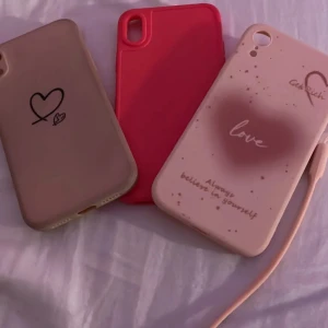 iPhone XR  Silikon Skal 3-pack - Tre snygga silikonfodral till iPhone XR  Färger: beige med hjärta, rosa och ljusrosa med text. Alla skal är i fint skick utan synliga skador, perfekta för att skydda din mobil och ge den en personlig touch.