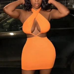 Två trendiga korta klänningar (finns i andra färger) - Säljer två snygga korta klänningar. Ena är helorange med korsad halterneck och cut-out detaljer,(finns i blå och svart)  andra har färgstarkt mönster i orange, gul och blå toner med ringdetalj framtill. Båda är tighta och ärmlösa, perfekta för dig som vill sticka ut.