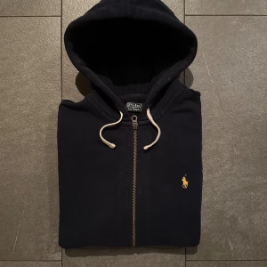 Zip tröja från Polo Ralph Lauren - Marinblå (Herr L) - Riktigt snygg mörkblå zip från Polo Ralph Lauren. Tröjan är i mycket bra skick (se bild för mått) och har ett nypris på ca 2200kr