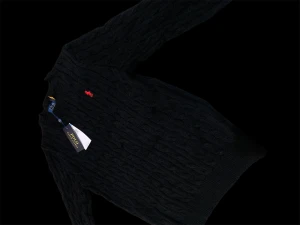 Svart kabelstickad tröja Polo Ralph Lauren - Svart kabelstickad tröja från Polo Ralph Lauren i 100% bomull. Klassisk rund hals, långärmad och med den ikoniska röda broderade loggan på bröstet. Perfekt för dig som gillar stilrena och tidlösa plagg med en sportig touch.