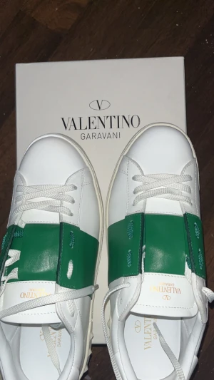 Valentino Garavani Open sneakers vit/grön - Snygga Valentino Garavani Open sneakers i vitt skinn med bred grön läder, passar perfekt nu till vinter och även sommar hör av er vid frågor