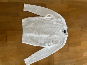 Vit stickad tröja från H&M - Säljer en vit stickad tröja från H&M i regular fit. Tröjan har ett grovt stickat mönster, rund hals och ribbade muddar vid ärmslut och nederkant. Perfekt för dig som gillar enkel och clean stil. Storlek S.