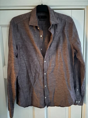 Riley linneskjorta  - Gråbrun ursnygg och populär Riley linneskjorta i storlek m säljes. Inga hål eller fläckar och mycket sparsamt använd. Tveka inte vid minsta fråga eller fundering🤩