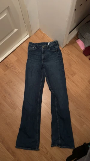 Mörkblå bootcut jesns midwaist - Midwaist bootcut jeans i storlek 32, lite slut ingar längst ned i byxbenet.