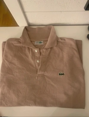 Beige pikétröja från Lacoste XL - Snygg beige pikétröja från Lacoste i storlek XL.          Använd endast 1 gång