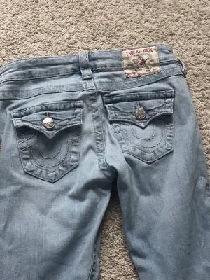 True Religion ljusblå jeans  - Snygga ljusblå jeans från True Religion med low rise flare har fickor där bak och är lite uppsydda men inte mycket i storlek 24 mycket bra skick🩵🩵