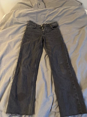 Svarta Wide/Straigth low jeans  - Svarta jeans med klassisk knappgylf och fem fickor. Jeansen har en rak passform och hög midja, tillverkade i robust denim. Perfekt för dig som gillar tidlös stil och vill ha ett par jeans som funkar till allt. Liten fläck på benet som säkert går bort med en tvätt💕💕Pris går att diskutera köpt på Zara