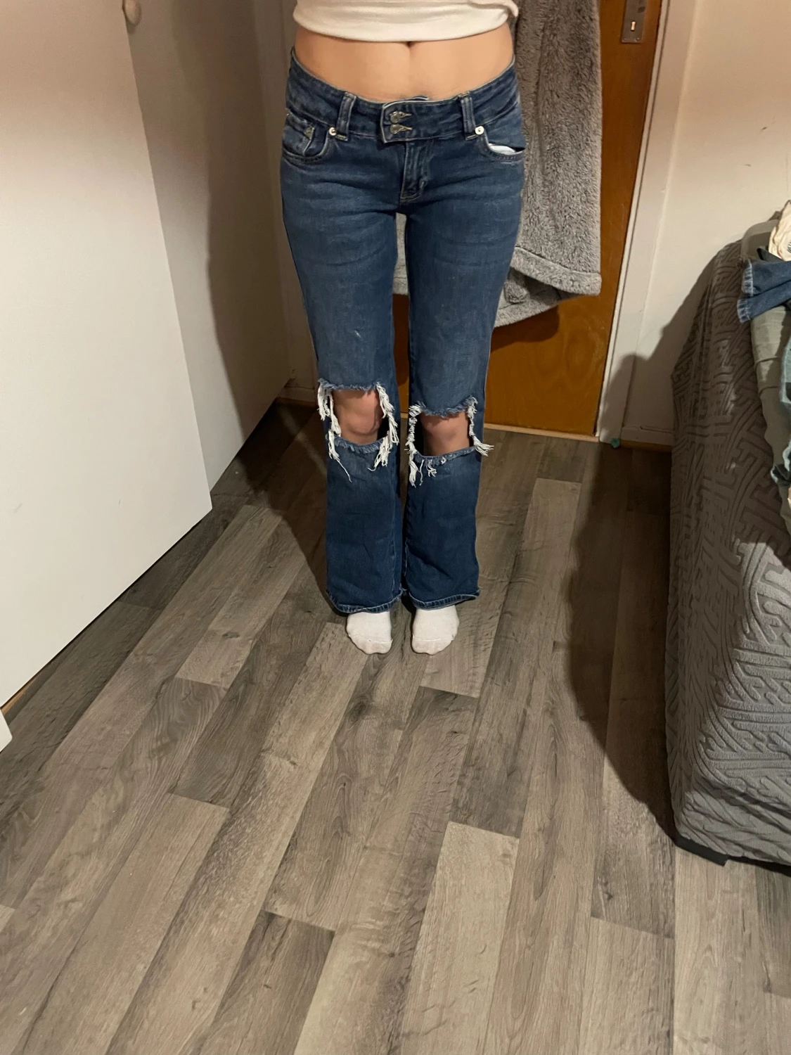 Blå bootcut jeans med slitna knän