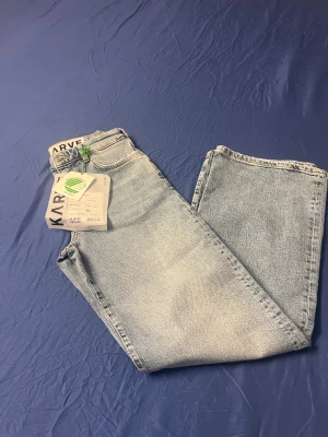 Ljusblå wide jeans från Karve XS - Säljer ett par ljusblå jeans från Karve i storlek XS. Jeansen har en klassisk femficksmodell, hög midja och raka, vida ben. Tillverkade i mjukt denimtyg som ger en avslappnad och trendig look. Perfekta för dig som gillar en loose och bekväm passform.