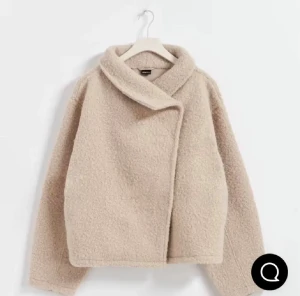 Beige teddyjacka med omlottkrage - Säljer en beige teddyjacka från Gina med omlottkrage och avslappnad passform. Jackan har långärmade ärmar och är gjord i mjukt teddy-material som ger en mysig vibe. Perfekt för dig som gillar stilren och chill look.