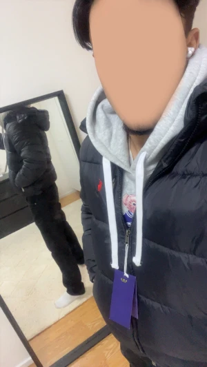 Svart pufferjacka från Polo Ralph Lauren - Svart pufferjacka från Polo Ralph Lauren med röd logga på bröstet. Jackan har huva, dragkedja framtill och flera fickor med dragkedja. Klassisk pufferstil med quiltade sektioner och en clean look som passar perfekt till vintern.