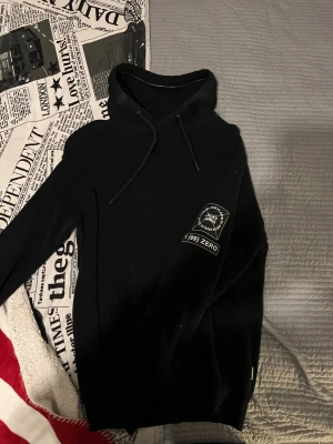 Jack & Jones hoodie - Aldrig använd Svart hoodie från Jack & Jones Core med ribbad stickad struktur och snörning i huvan. Långärmad modell med tryckt patch på ena ärmen. Perfekt för dig som gillar en enkel och stilren look med street-vibe.