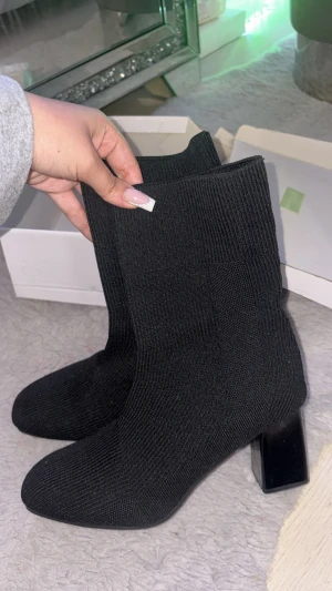 Svarta stickade stövletter med klack - Säljer dessa superfina och trendiga boots! Använda endast 1 gång, i mycket fint skick. • Stretchigt stickat material • Bekväma och stabila klackar • Passar både till vardag och fest • Storlek: 39