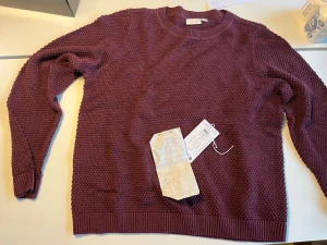 Vinröd stickad tröja från VILA. Helt ny - Säljer en vinröd stickad tröja från VILA i storlek XL. Tröjan har en chunky struktur, rund halsringning och ribbade muddar vid ärmslut och nederkant. Såg inte förrän jag klippt av lappen att jag köpt helt fel storlek, så den är helt ny och oanvänd.