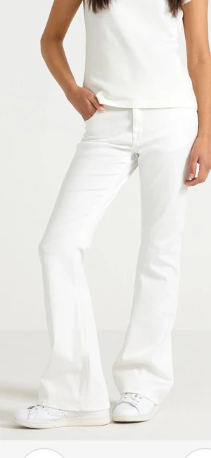 Vita bootcut jeans från Lindex - Snygga vita jeans från Lindex med bootcut passform och klassisk femficksdesign. Byxorna har hög midja och är tillverkade i mjuk bomull med lite stretch för extra komfort. Perfekta att styla med sneakers eller chunky boots för en fräsch look.