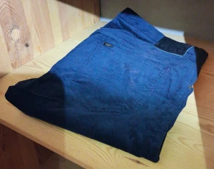 Mörkblå manchesterbyxor från Lee - Snygga mörkblå manchesterbyxor från Lee, modell Daren Zip Fly. Byxorna har klassisk femficksdesign, zip-fly och ett Lee-märke på bakfickan. Perfekt för dig som gillar retrovibe och vill sticka ut med ett coolt materialval.