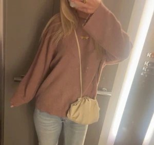 Rosa stickad tröja - Säljer en rosa stickad tröja. Tröjan har en enkel design med ribbade muddar vid ärmslut och nederkant. Perfekt för att skapa en chill och avslappnad look. Har inga defekter alls!