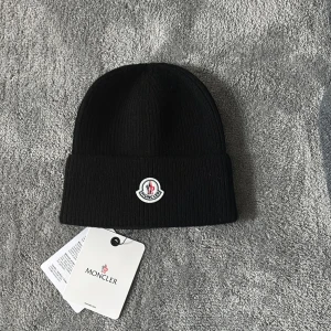 Moncler mössa - En svart mössa från moncler. HÖR AV DIG VID FUNDERINGAR!💸