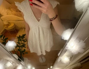 Vit klänning - Vit v-ringad klänning med broderi och volanger i storlek XS