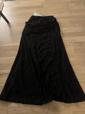 Maxikjol - Svart lång kjol från Gina Tricot. Går enda ner till fötterna och den är lite utsvängd längst ner så den faller superfint. Kjolens längd är ca 100cm. Storlek XS. Helt ny med prislapp kvar. 