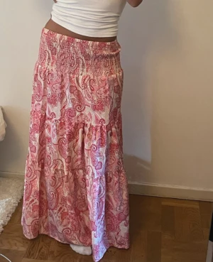 Rosa långkjol med super fina mönster - Säljer en super fin långkjol från shein, inga defekter (säljer för att jag har två styckna)❤️Så fin till sommaren och speciellt utomlands!