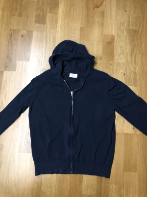 Mörkblå hoodie från Grunt XL - Snygg mörkblå hoodie från Grunt i storlek XL.”TRÖJAN ÄR STORELK XL I BARN, VILKET MOTSVARAR STORLEK S I VUXEN” Tröjan har dragkedja framtill, huva och långa ärmar. Tillverkad i mjuk bomull som är skön att ha på sig. Perfekt för chill dagar och enkel att matcha med jeans eller joggers. Pris går att diskutera mvh Rasmus”