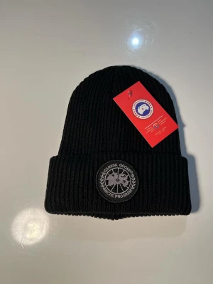 Mössa Canada Goose - Helt ny och oanvänd Canada Goose mössa, 10/10 skick. Riktig fin och bekväm. Varm till vintern!