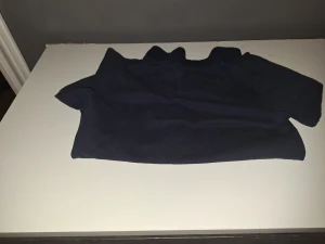 Mörkblå pikétröja från 157 - Snygg mörkblå pikétröja från 157 i storlek 160. Klassisk krage och korta ärmar med två knappar framtill. Tröjan är gjord i mjuk bomull som känns skön mot huden och passar perfekt till en chill stil. Enkelt och stilrent plagg för dig som gillar basic.