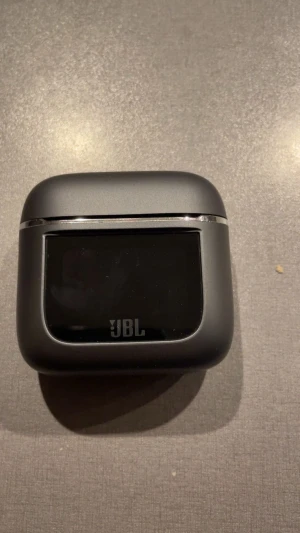 JBL Tour Pro 2 - JBL Tour Pro 2 trådlösa hörlurar med smart laddningsetui med display. Funktioner som adaptiv brusreducering, 6 mikrofoner för klara samtal, trådlös laddning och upp till 30 timmars batteritid. Produkten och förpackningen ser ut att vara i mycket gott skick.