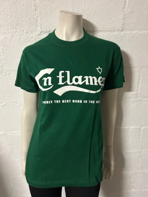 Grön t-shirt med In Flames-tryck - Snygg grön t-shirt från Rock Off med tryck av bandet In Flames. Texten 'Probably the best band in the world' finns under loggan. Perfekt för fans av bandet!