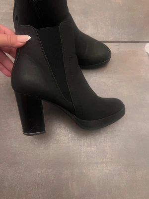 Svarta stövletter med klack från Anna Field - Snygga svarta stövletter från Anna Field med rund tå och hög blockklack. Skorna har dragkedja på sidan. Använda få gånger , jätte fint skick
