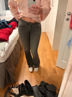 Grå bootcut jeans från Diesel  - Säljer ett par gråa bootcut jeans från Diesel i storlek W27. De passar mig perfekt i längden och jag är 170cm. Jeansen har en snygg låg midja och klassisk femficksdesign. Materialet är mjukt och stretchigt för skön passform. Perfekta om du gillar en lite retro siluett med utsvängda ben.