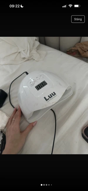 Luu Professional UV/LED Nagellampa - Luu Professional UV/LED nagellampa med digital display och timerfunktion (10s, 30s, 60s, 99s). Perfekt för gelnaglar och salongsresultat hemma. Några ytliga fläckar och slitage syns, men lampan är fullt fungerande. Stor öppning och flera LED-dioder för jämn härdning. Funkar utmärkt 
