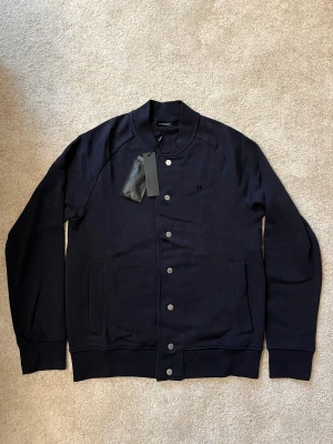 Helt ny J.Lindberg cardigan  - Helt ny J.Linberg cardigan aldrig använd med alla tags kvar.                                                               ————————————————————————                                                              📐| Storlek: M                                                          👖| Märke: J.Linberg                                               🔎 | Skick: 10/10 helt ny                                         💵 | Ny Pris:  1999kr                                           