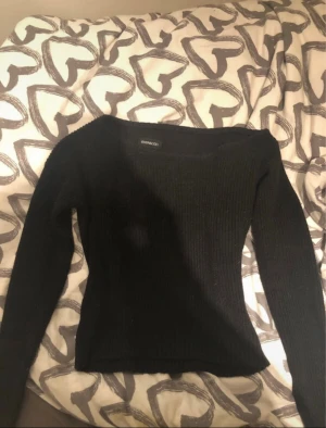 Svart ribbad stickad tröja Even&Odd - Svart stickad tröja från Even&Odd med ribbad struktur och långärmad design. Tröjan har en klassisk rund hals och sitter snyggt med en normal passform. Perfekt för dig som gillar stilrena och enkla plagg med lite edge.