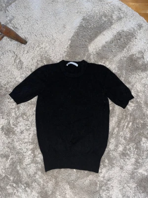 Zara Topp Stickad - En finarickad T-shirt topp från Zara. Använt sällan, bra skick. Svart i storlek S. Perfekt till snygga jeans!!😍