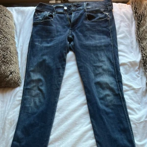 Replay Anbass Hyperflex jeans blå - Mörkblå Replay Anbass Hyperflex jeans i slim fit med klassisk femficksdesign och snygga slitningar. Jeansen har en bekväm stretchig känsla och tydliga Replay-detaljer på bakfickan och patch i midjan.