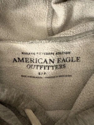 Grå hoodie från American Eagle - Säljer nu denna sjukt eftertraktade hoodie från American eagle. Skick 8/10, sjukt snygg och passar perfekt nu till hösten. Obs kan gå ner i pris vid snabb affär!