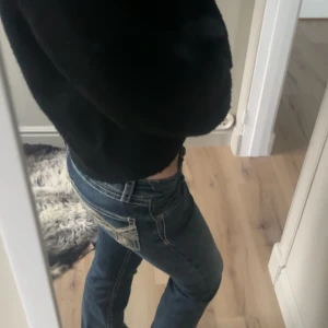 Blå bootcut jeans från Gina Tricot - Snygga blå jeans från Gina Tricot med bootcut passform och kontrastsömmar. Jeansen har dekorativa fickor bak med detaljer och är tillverkade i klassiskt jeansmaterial. Perfekt för dig som gillar en cool och avslappnad stil.