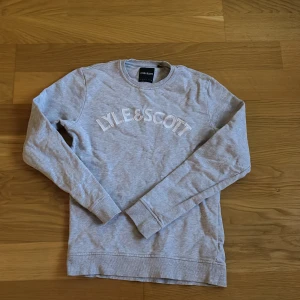 Grå sweatshirt från Lyle & Scott - Snygg grå sweatshirt från Lyle & Scott med broderad logga framtill. Nästan i helt nyskick. 