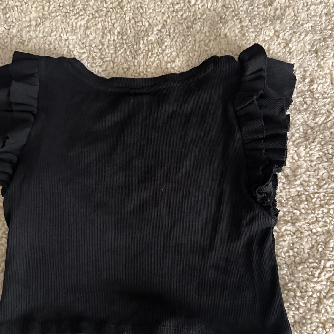 Svart ribbad topp med volangärmar - 1