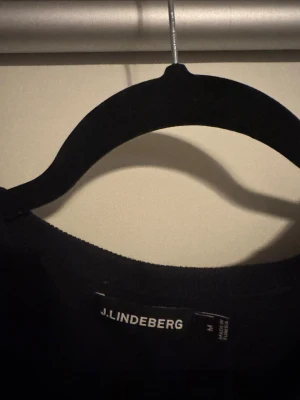 Marinblå långärmad  tröja J.Lindeberg - Marinblå långärmad tröja från J.Lindeberg i stilren design. Tröjan har rund hals och är tillverkad i mjukt material som passar perfekt för en clean och enkel look. Säljer då den inte kommer till användning 